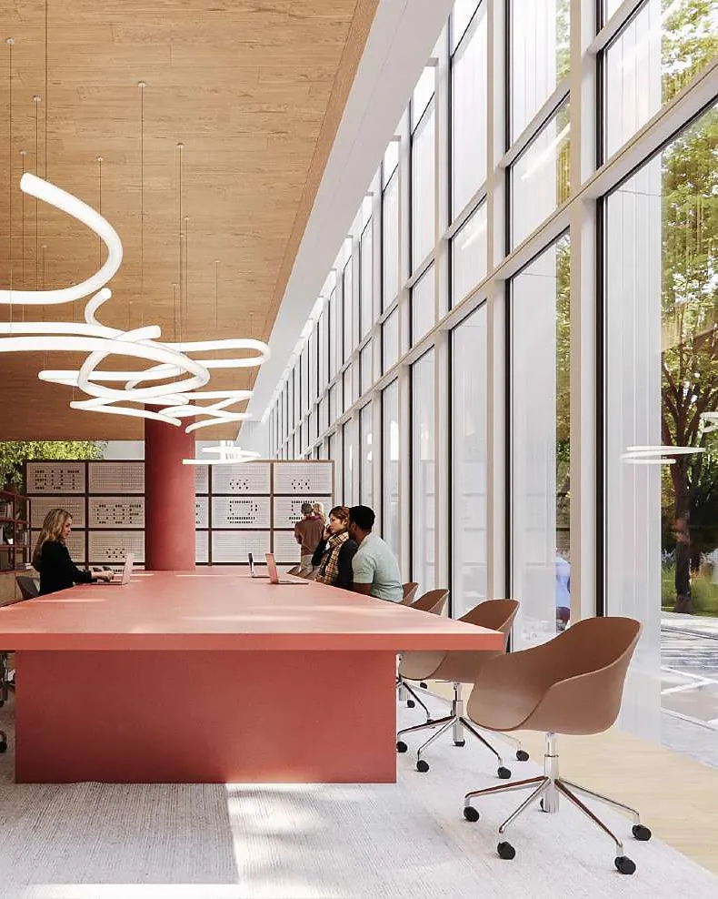Long oxide-red communal table under a sculptural pendant light